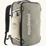 Patagonia 30 litre black hole travel backpack in beige with black trim  showing the mesh side pocket with a bottle inside
