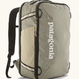 Patagonia 30 litre black hole weather resistant travel backpack in beige with black trim. Features padded shoulder pads, zipper fasteners and mesh side pocket