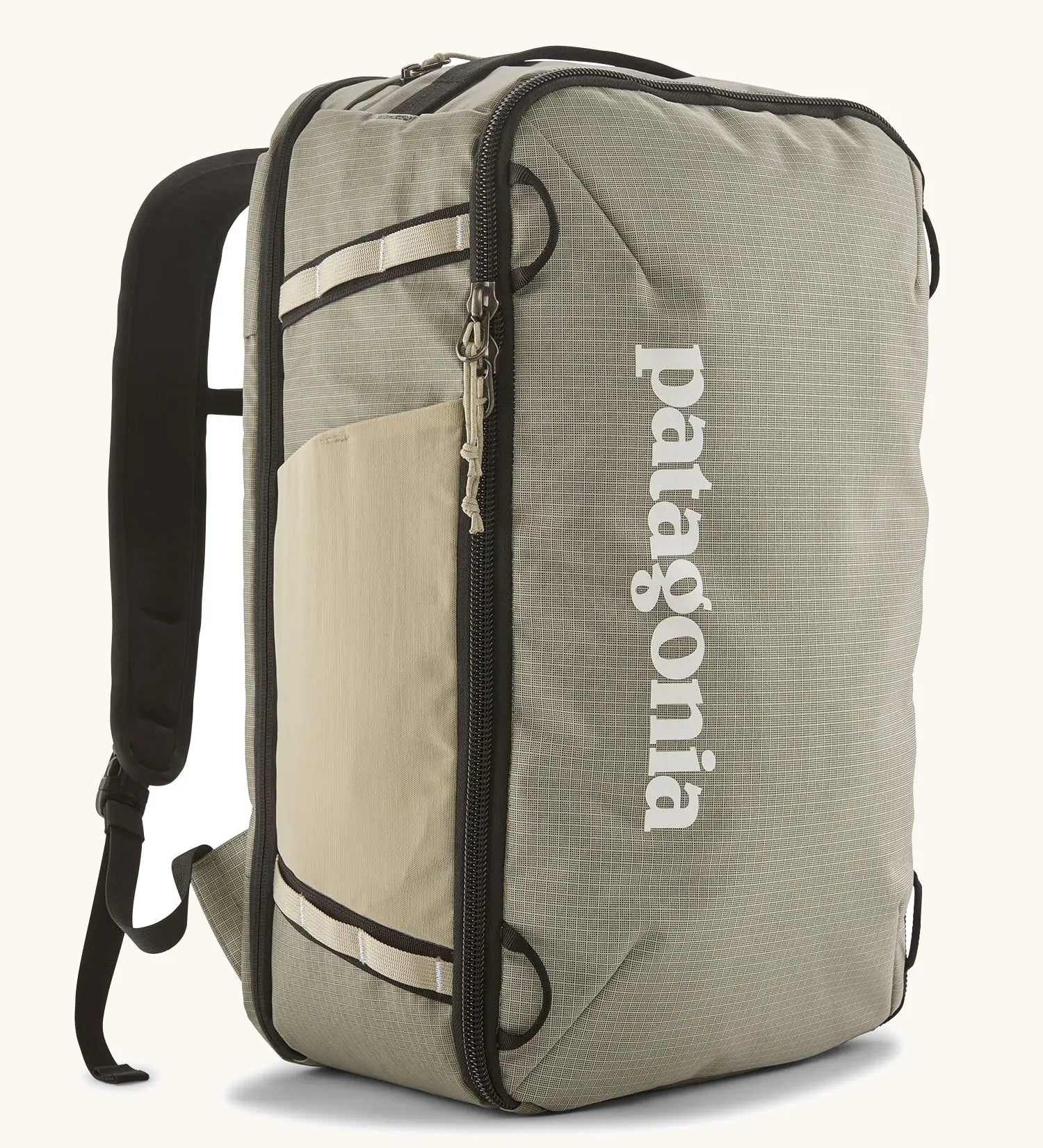 Patagonia 30 litre black hole weather resistant travel backpack in beige with black trim. Features padded shoulder pads, zipper fasteners and mesh side pocket