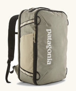 Patagonia 30 litre black hole weather resistant travel backpack in beige with black trim. Features padded shoulder pads, zipper fasteners and mesh side pocket