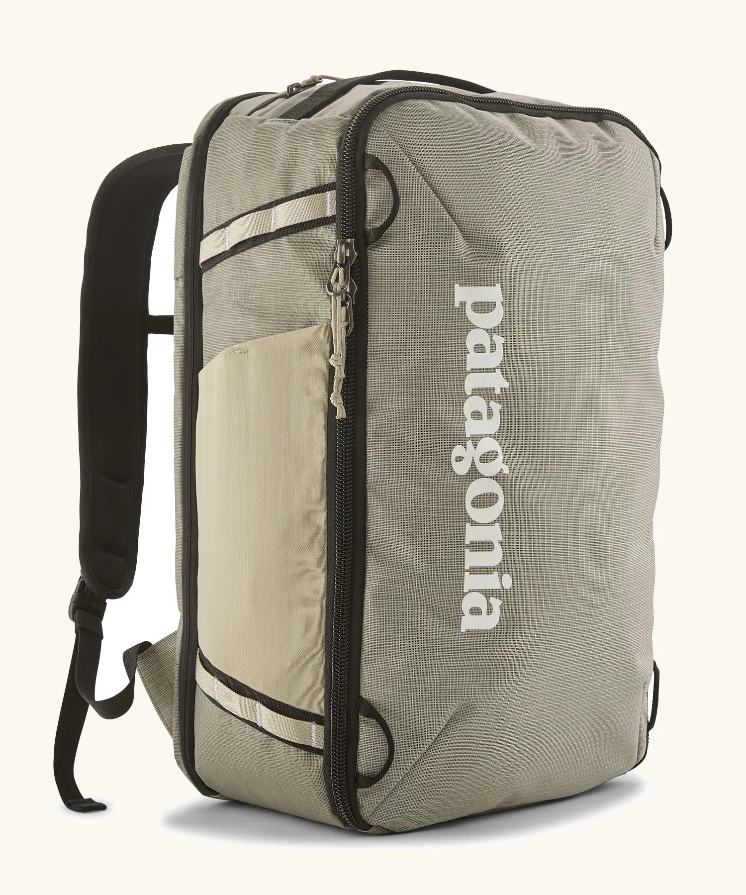 Patagonia 30 litre black hole weather resistant travel backpack in beige with black trim. Features padded shoulder pads, zipper fasteners and mesh side pocket