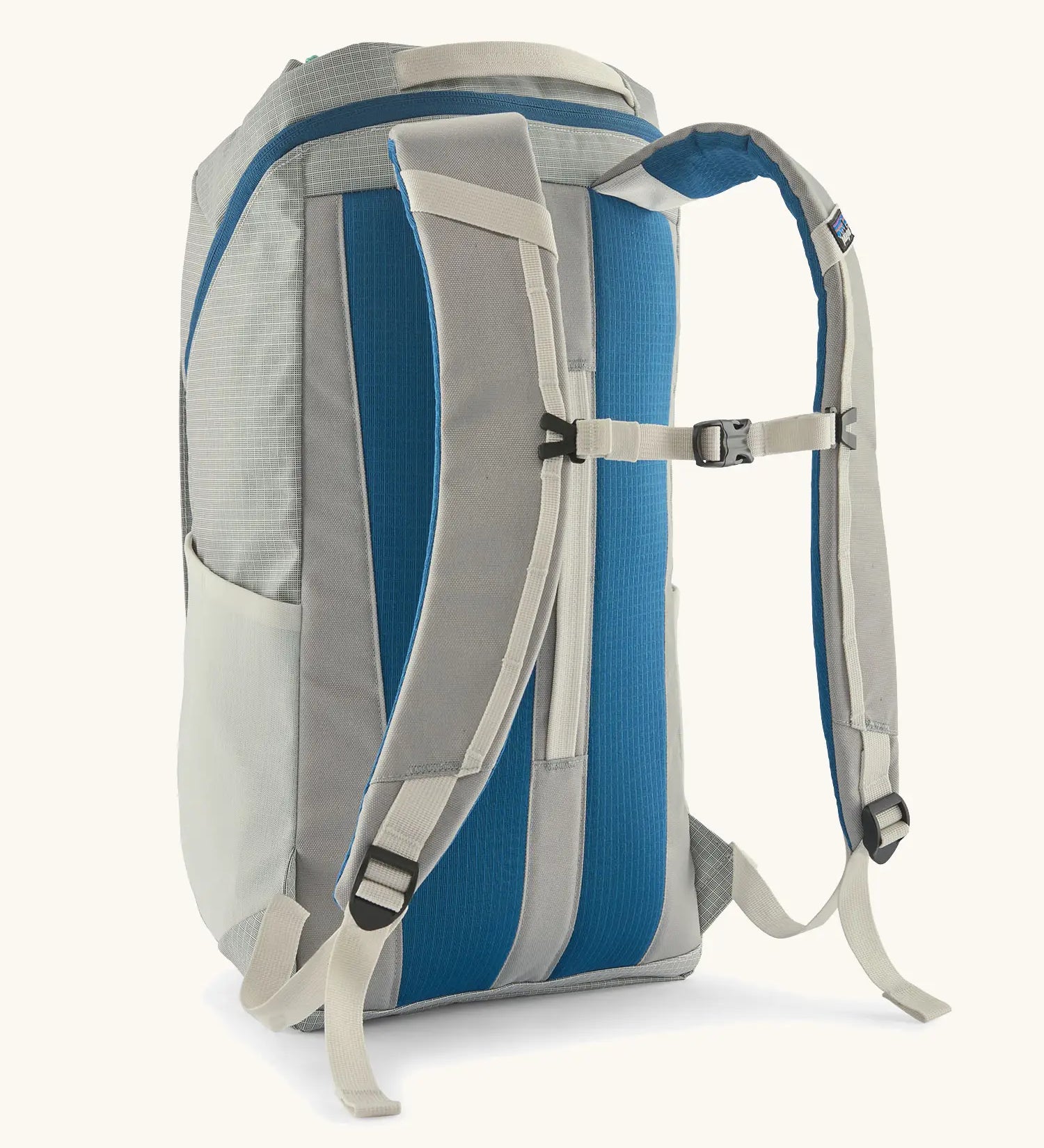Patagonia black hole backpack 25L in birch white with chest straps and a blue back panel.