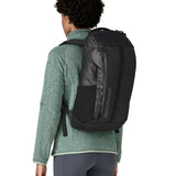 An adult facing away and wearing the Patagonia Black Hole Backpack 25 litre capacity backpack in all black available at Babipur showing the fit of the backpack