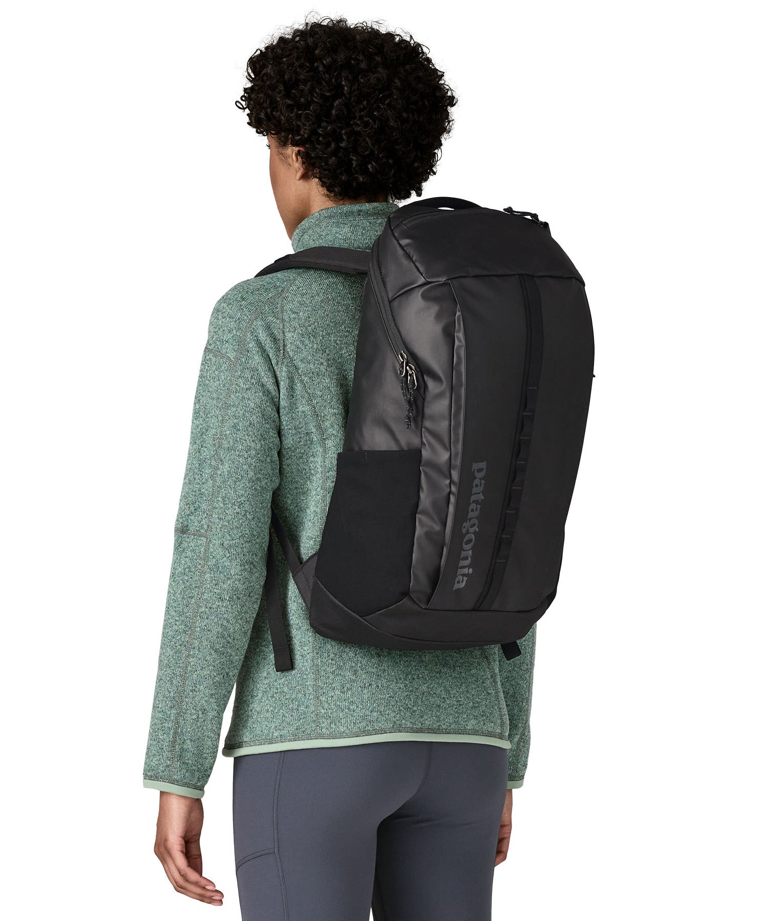 An adult facing away and wearing the Patagonia Black Hole Backpack 25 litre capacity backpack in all black available at Babipur showing the fit of the backpack