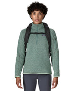 An adult facing forward and wearing the Patagonia Black Hole Backpack 25 litre capacity backpack in all black available at Babipur showing the buckle clip holding the padded shoulder straps close together 