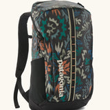 Patagonia black hole backpack 25L in black with repeating abstract pattern design. Shows zipped compartment and mesh side pocket