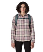 Front of woman carrying a Patagonia 100% recycled polyester black hole 25 litre backpack in teal showing the chest strap fastened