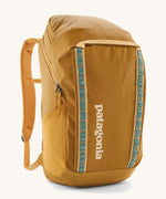 The Patagonia Black Hole Pack 32 litre capacity backpack in a Beeswax Tan golden yellow colour with teal details.