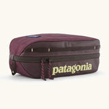 Patagonia compact 3L black hole cube travel bag in maroon. Showing a zip fastener with the brand name on the top panel