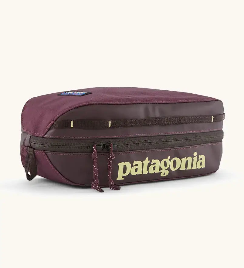 Patagonia compact 3L black hole cube travel bag in maroon. Showing a zip fastener with the brand name on the top panel