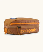 Patagonia 3L black hole cube travel bag in cinnamon brown. Showing a zip fastener with the brand name on the top panel