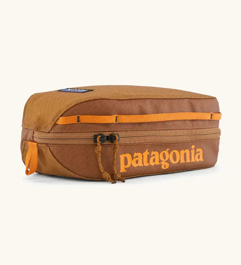 Patagonia 3L black hole cube travel bag in cinnamon brown. Showing a zip fastener with the brand name on the top panel