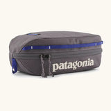 Patagonia 3L black hole cube travel bag in dark grey and blue trim. Showing a zip fastener with the brand name on the top panel