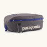 Patagonia 3L black hole cube travel bag in dark grey and blue trim. Showing a zip fastener with the brand name on the top panel
