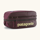 Patagonia black hole 6 litre cube bag in maroon with a double zip fastener showing the brand print on front panel