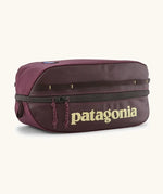 Patagonia black hole 6 litre cube bag in maroon with a double zip fastener showing the brand print on front panel
