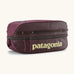 Patagonia black hole 6 litre cube bag in maroon with a double zip fastener showing the brand print on front panel