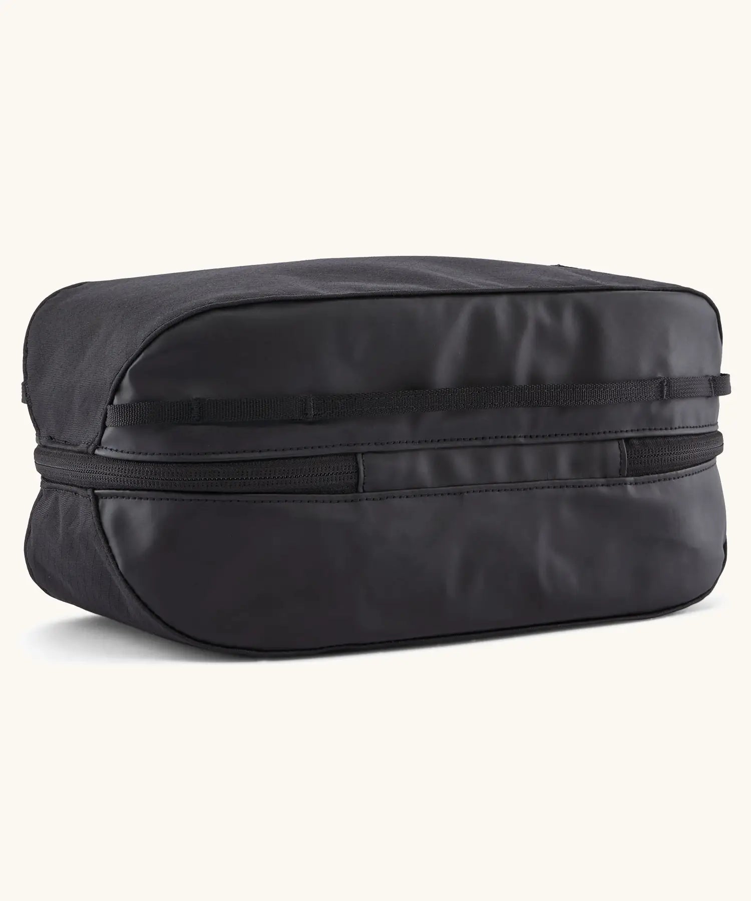 Underside of Patagonia black hole 6 litre cube bag in all black showing a protective laminate panel