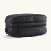 Patagonia black hole 6 litre cube bag in all black with a double zip fastener showing the brand print on front panel