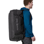 A person carrying the Patagonia Black Hole Duffel 70L Black on their back