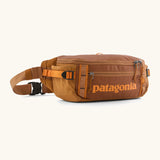 Patagonia 100% recycled nylon black hole waist 5L pack in cinnamon brown showing 2 compartments with mesh side pockets and buckle fastener 