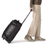 Woman pulling a Patagonia 40 litres black hole wheeled duffel bag in all black using the retractable handle