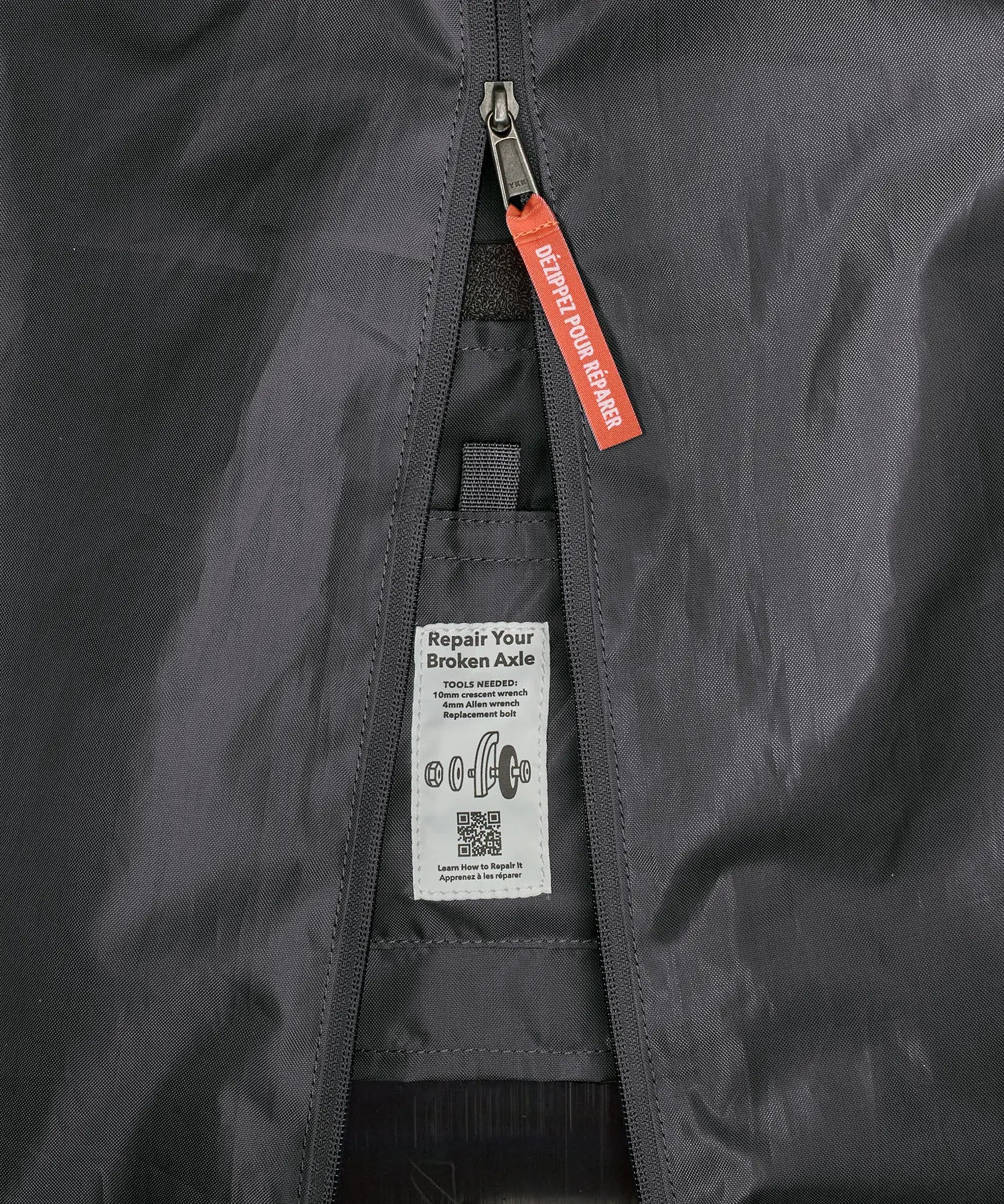 Patagonia black hole 70 litre wheeled duffel bag in dark blue showing close up of tag for repairing the axle.