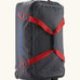 Patagonia black hole 70 litre wheeled duffel bag in dark blue with red straps. Features extra loops for attaching small items and retractable handle