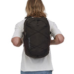 A person wearing the Patagonia Refugio Day Pack 30L Black