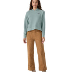 A person wearing the Patagonia Women's Regenerative Essential Hoody and yellow coloured corduroy trousers 