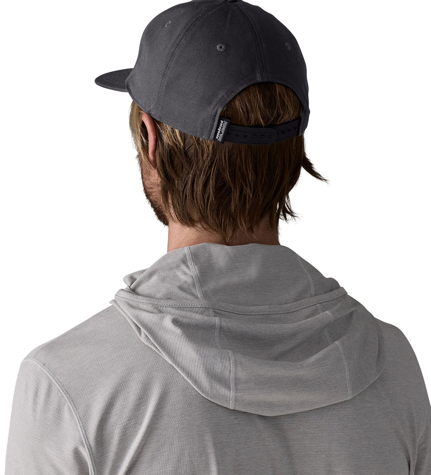Man wearing Patagonia's boardshort label funfarer cap in black showing adjustable strap on the back. Cap has a relaxed fit and sits above the ears