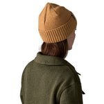 The back of a woman wearing the Patagonia adult brodeo beanie hat in talon gold available at Babipur.
