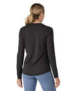 A woman modelling the Patagonia women's capilene cool merino blend long sleeve t-shirt in black available at Babipur showing the back fit