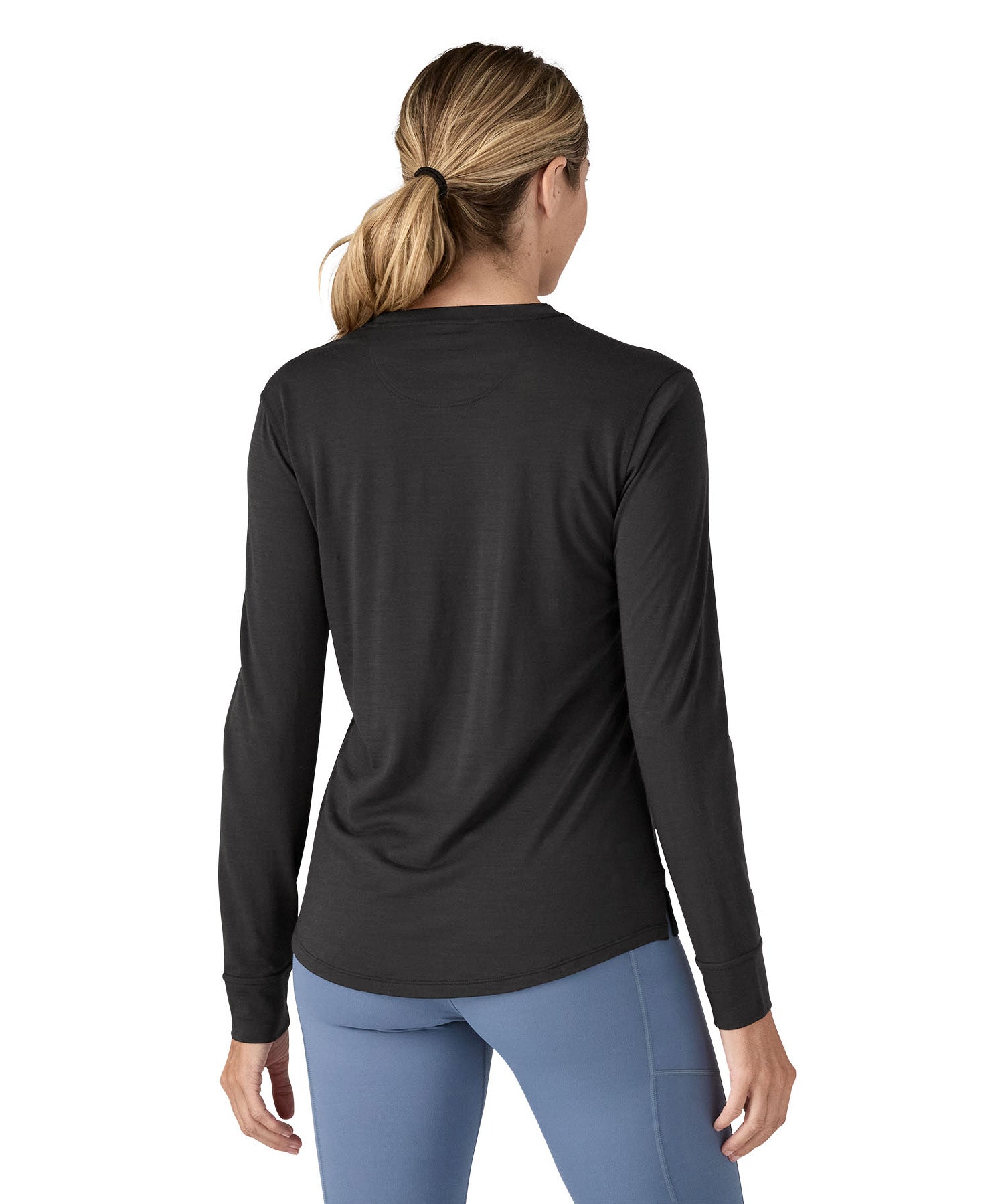 A woman modelling the Patagonia women's capilene cool merino blend long sleeve t-shirt in black available at Babipur showing the back fit