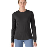 A woman modelling the Patagonia women's capilene cool merino blend long sleeve t-shirt in black available at Babipur showing the front fit