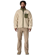 A man wearing the Patagonia classic retro x jacket in natural/green available at Babipur.