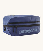 Patagonia black hole 6 litre cube bag in current blue. A 100% recycled material cube bag in dark blue with black detail. Features 1 main zip compartment with a light blue brand text on the top and a brand patch stitched on the side