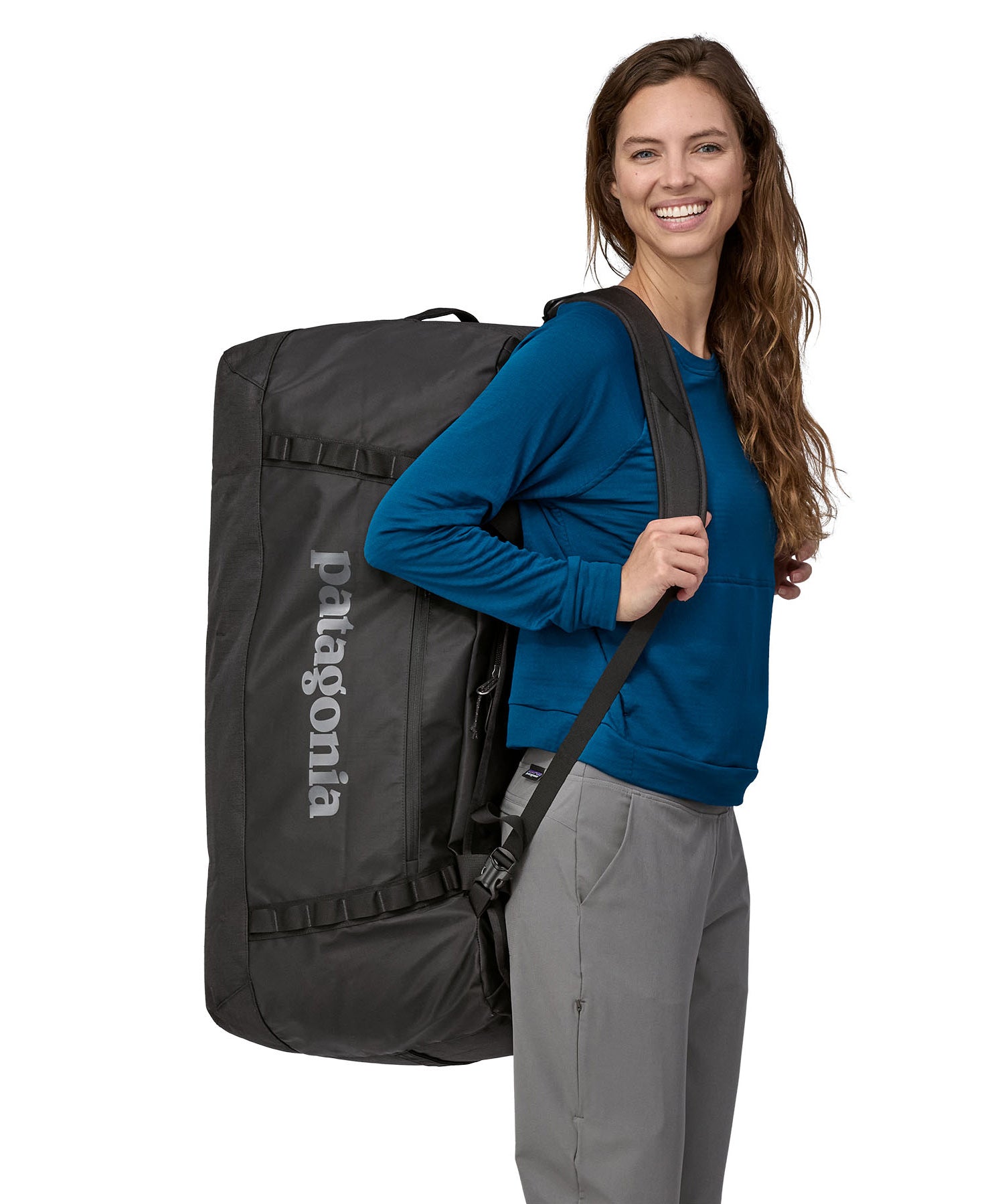 A person carrying the Patagonia Black Hole Duffel 100L Black on their back with the shoulder straps