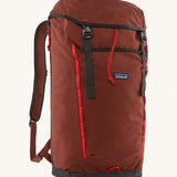 Patagonia lid fieldsmith lid backpack in dried vanilla. A 100% recycled material backpack in deep red with black and red  detail. Features a lid style top cover with buckle fastenings and padded shoulder straps