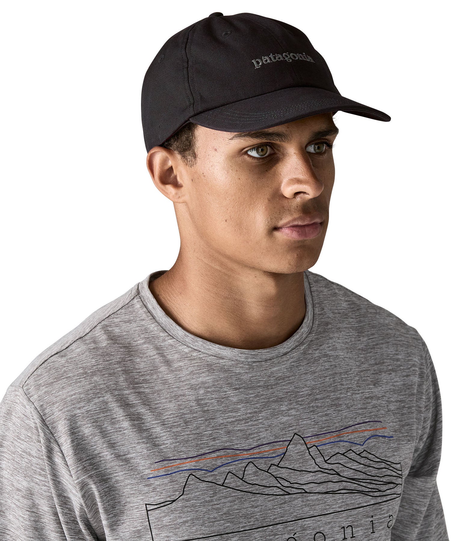 Man wearing Patagonia's organic cotton fitz roy icon trad cap in black with brand text on the front. 