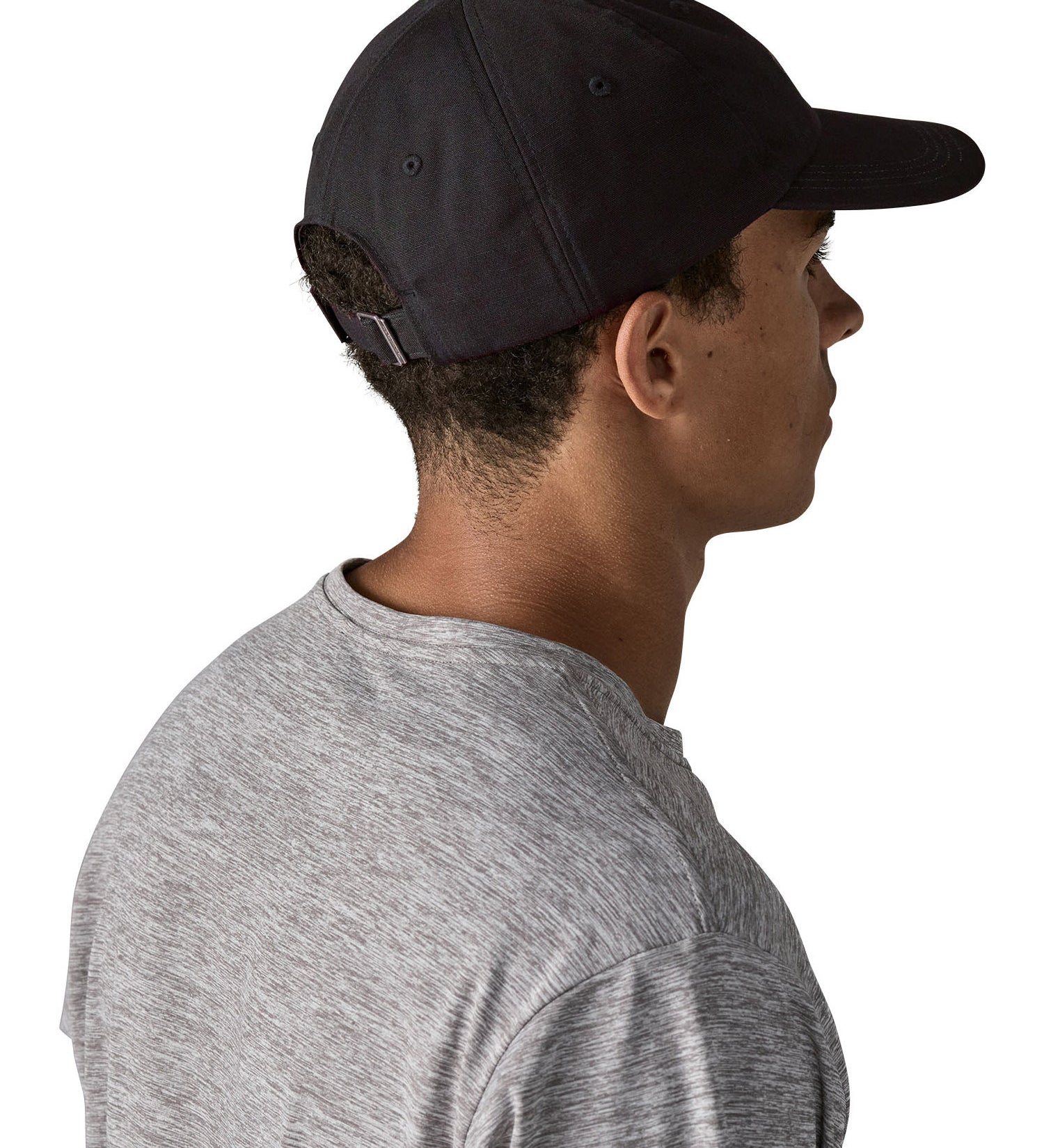 Man wearing Patagonia's organic cotton fitz roy trad cap in black. Shows the adjustable strap on the back