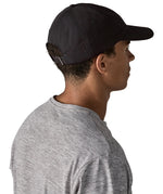 Man wearing Patagonia's organic cotton fitz roy trad cap in black. Shows the adjustable strap on the back