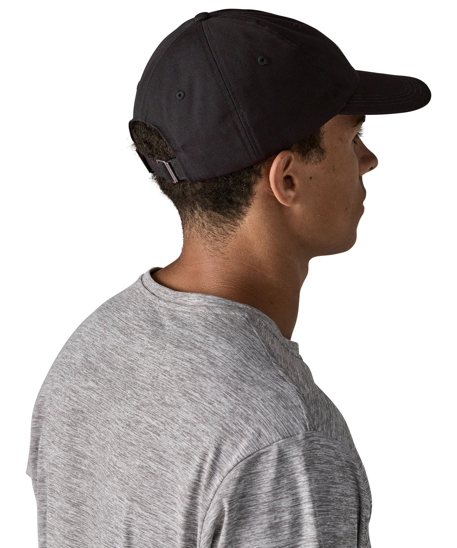 Man wearing Patagonia's organic cotton fitz roy trad cap in black. Shows the adjustable strap on the back