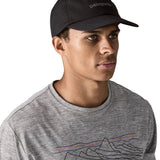 Man wearing Patagonia's organic cotton fitz roy trad cap in black with brand text on the front. 