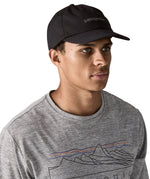 Man wearing Patagonia's organic cotton fitz roy trad cap in black with brand text on the front. 