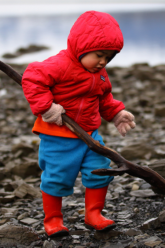 Child playing outside wearing a Patagonia down jacket and a pair of Patagonia fleece dungarees to represent Pataognia kids at Babipur.