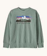 Patagonia Kids Cotton crew Sweatshirt in Cover Green. A sage green body with a vintage-style Patagonia Fitz Roy Foothills logo on the chest.