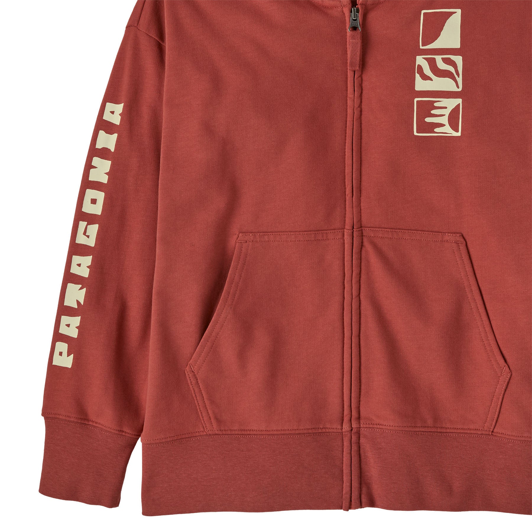 A close up of the Patagonia kids full zip hoody sweatshirt in mother ray/potters red available at Babipur showing the pocket and cream graphic detail.