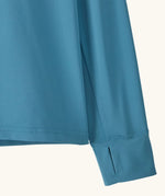 Close up of Patagonia kids long sleeve capilene tshirt in bright blue showing thumb hole on sleeve