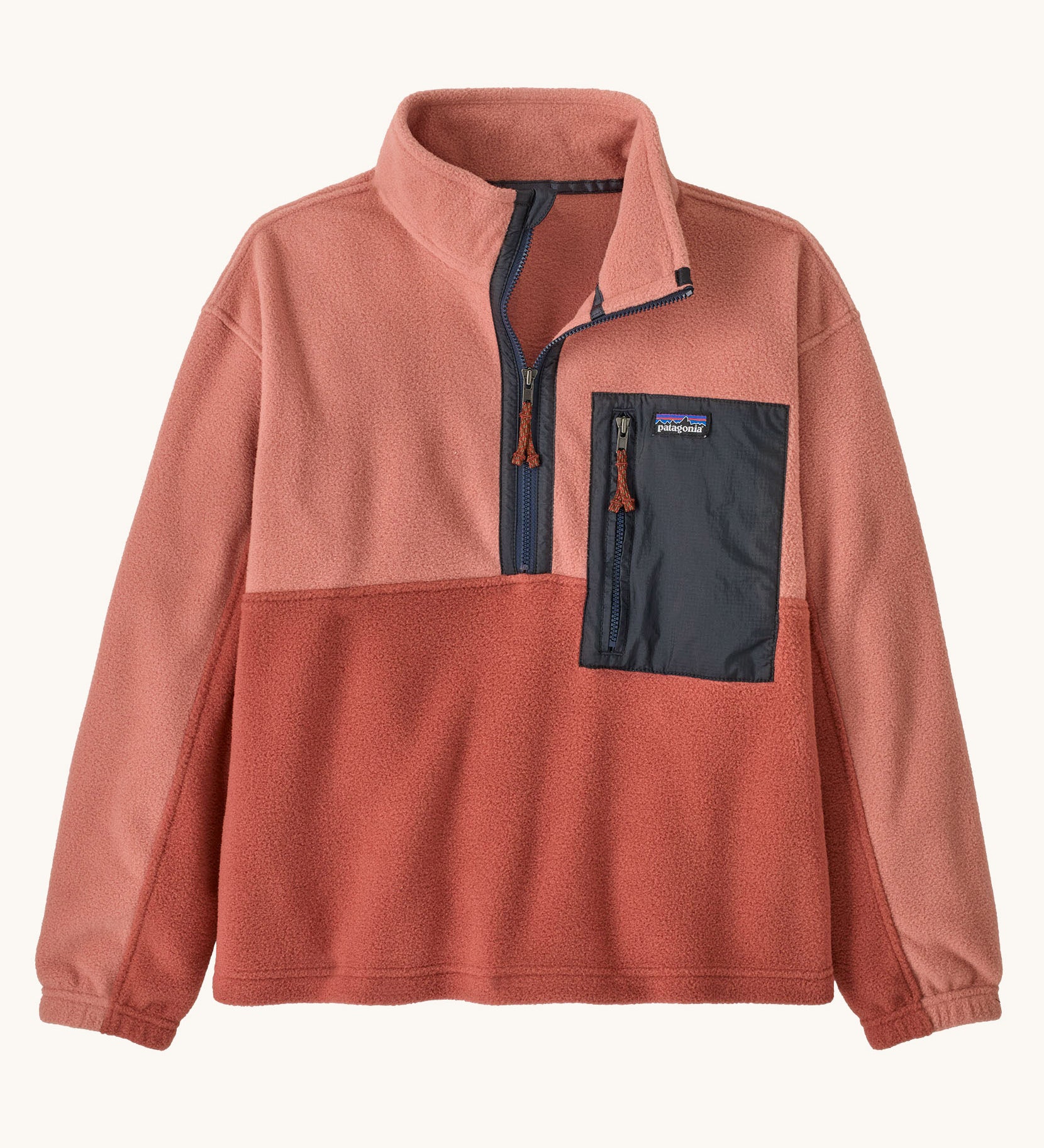 Patagonia kids microdini 1/2 zip pullover in potters red available at Babipur. A 100% recycled polyester soft fleece in pale red with navy trim. Features a turn up collar with a half length zip, elasticated cuffs and a chest pocket.